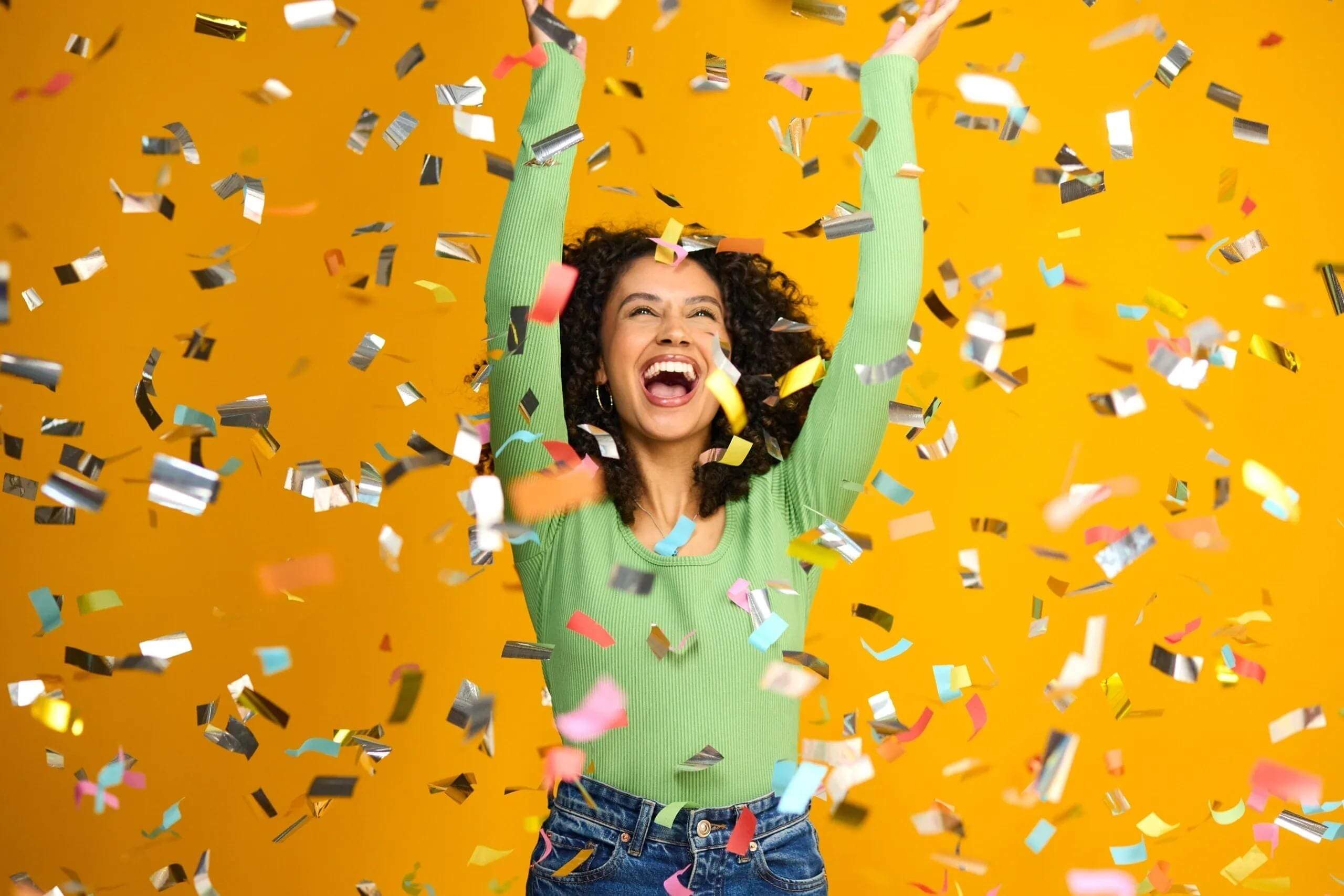 Woman celebrating with colorful confetti falling.