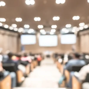 A large audience is in the middle of an auditorium.