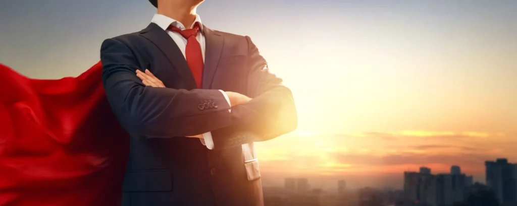 Businessman with red cape at sunrise.