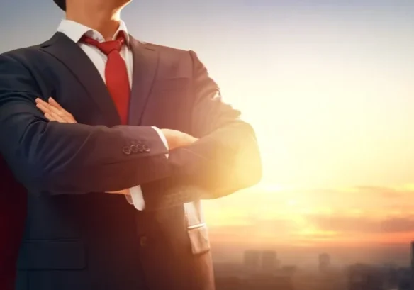 Businessman with red cape at sunrise.